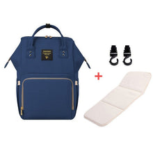 Blue backpack with a white mat and black hooks.