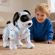 Smiling boy in a blue sweater lying on a carpet in front of a white robot dog with black ears