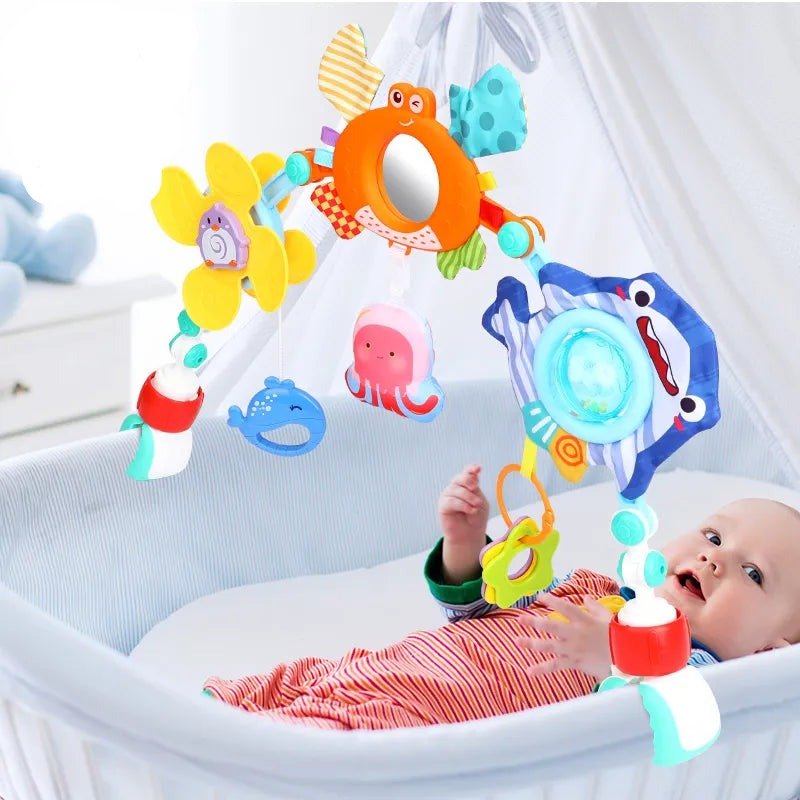 Baby in crib with colorful mobile toy