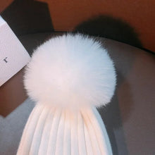 Close-up of the natural mink fur pom pom topper that finishes this kids knitted winter beanie.