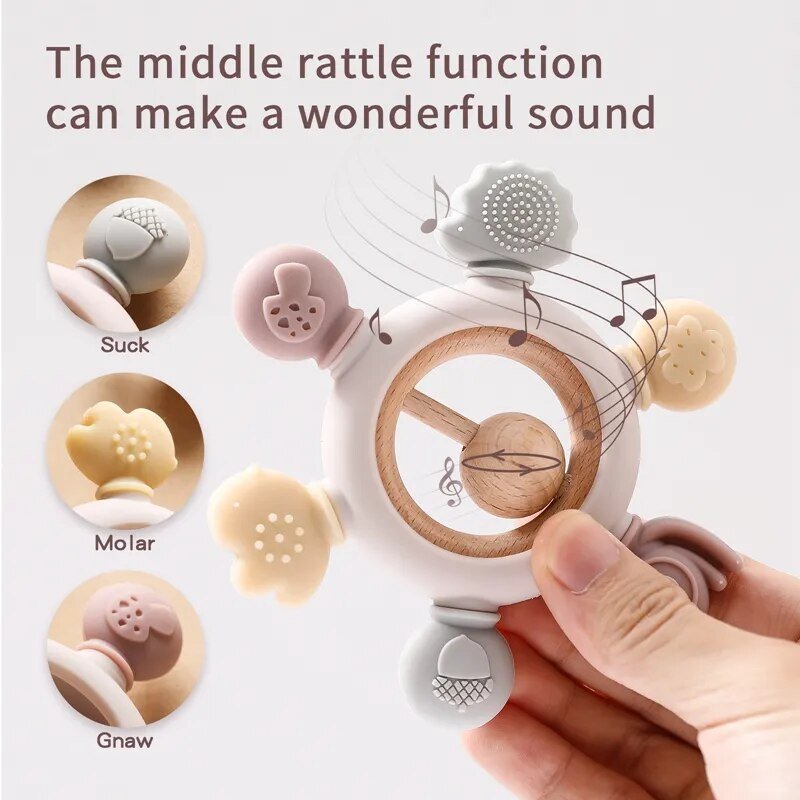 Baby teething ring with multiple functions and a hand holding it.