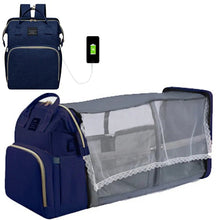 Fold-out baby bed mommy backpack in navy blue, featuring a mesh compartment and charging cable.