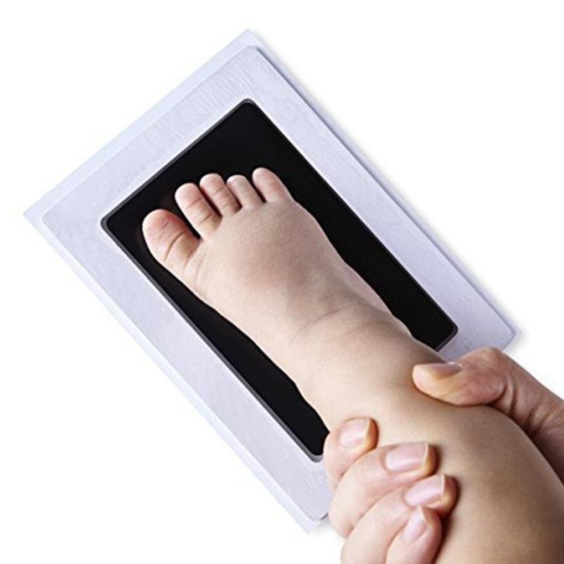 Taking a baby foot print with the non-toxic imprint kit for a mess-free newborn keepsake at home.