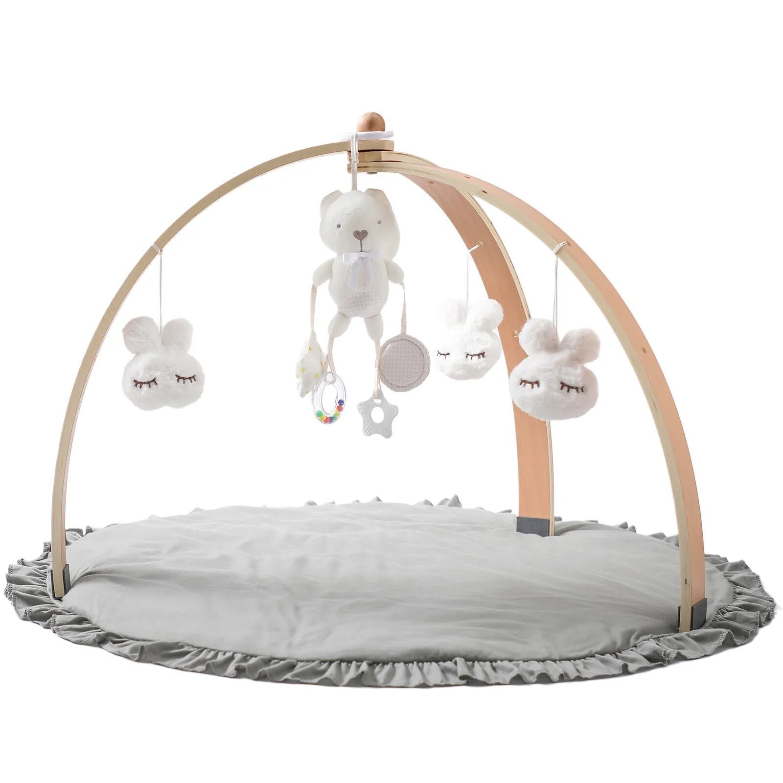 Wooden baby play gym styled on a nursery floor with hanging mobile elements for supervised sensory play.