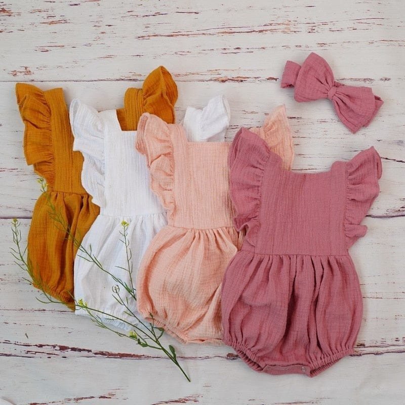 Organic cotton baby girl romper and headband sets displayed together for everyday wear, gifting, and newborn photo sessions.