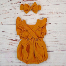 Mustard organic cotton ruffle romper laid flat with headband, a soft everyday outfit for crawling and nursery play.