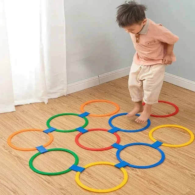 Child playing with colorful ring game on a wooden floor