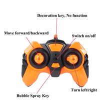 Orange and black remote controller for the Paisible RC bubble car, with simple buttons for young children to steer.