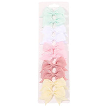 Pastel bow hairpins in soft colours for gentle everyday girls hairstyles and photo days.