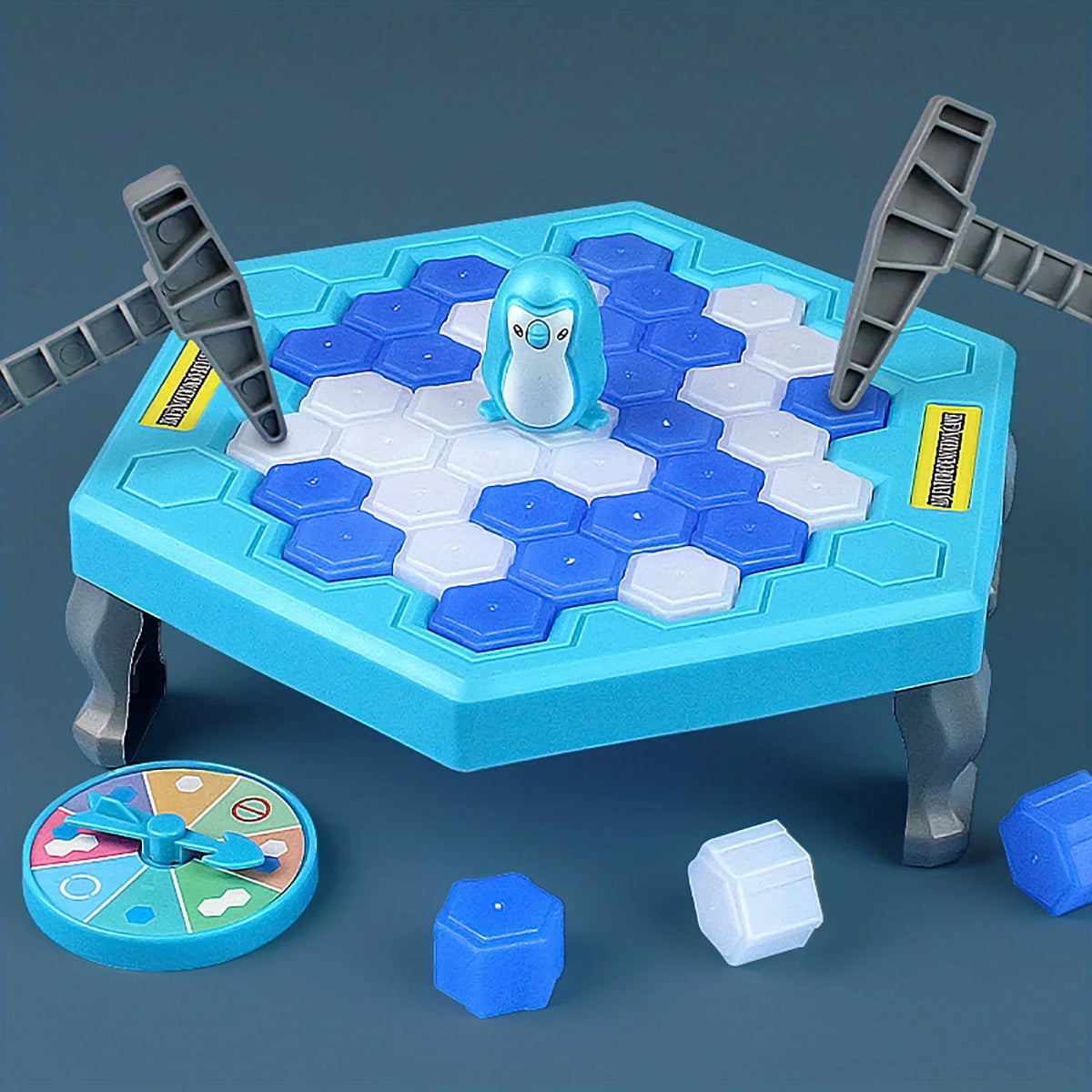 Blue ice table with a penguin, two hammers, a spinner and loose ice blocks on a dark blue background