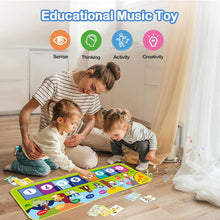 Piano dance mat floor keyboard used by a parent and two children for interactive family play sessions.