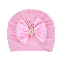 Pink baby turban with bow and jewel detail for birthdays, photos, and everyday soft head coverage.