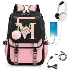 Pink and black backpack with floral design, phone, headphones, and USB cable.
