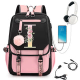 Pink and black backpack with floral design, phone, headphones, and USB cable.