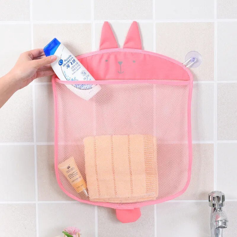 Pink bunny mesh bath toy storage bag mounted on a bathroom wall for tidy storage.
