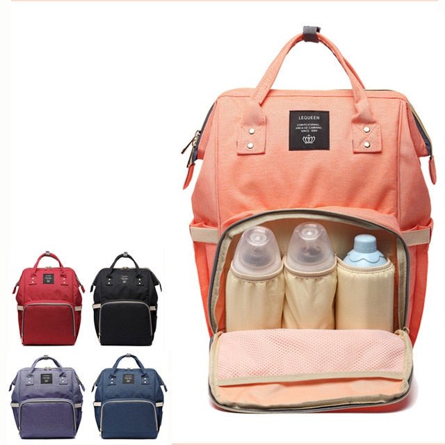 Pink diaper bag set styled with bottles, a towel, and matching pouches for organized baby travel.