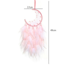 Pink feather dream catcher crafted as rustic boho rattan art for wall decor.