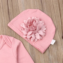 Close-up of the flower trim on the pink baby outfit, showing the breathable cotton used for newborn skin comfort.
