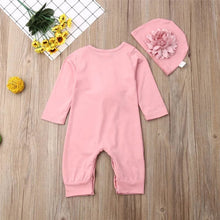 Pink floral baby romper and hat set styled with fresh flowers, a cotton outfit for christenings and spring outings.