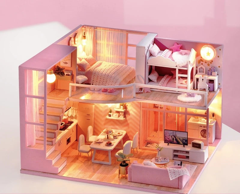 Wooden dollhouse craft kit with pink interior and included furniture for hands-on building fun.