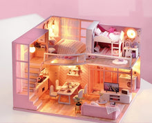 Wooden dollhouse craft kit with pink interior and included furniture for hands-on building fun.