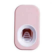 Pink modern auto toothpaste dispenser and holder set for kids and adult brushing routines.