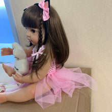Pink Princess Reborn bath doll in soft silicone seated with a teddy bear for bathing play, cuddling, and nursery display.
