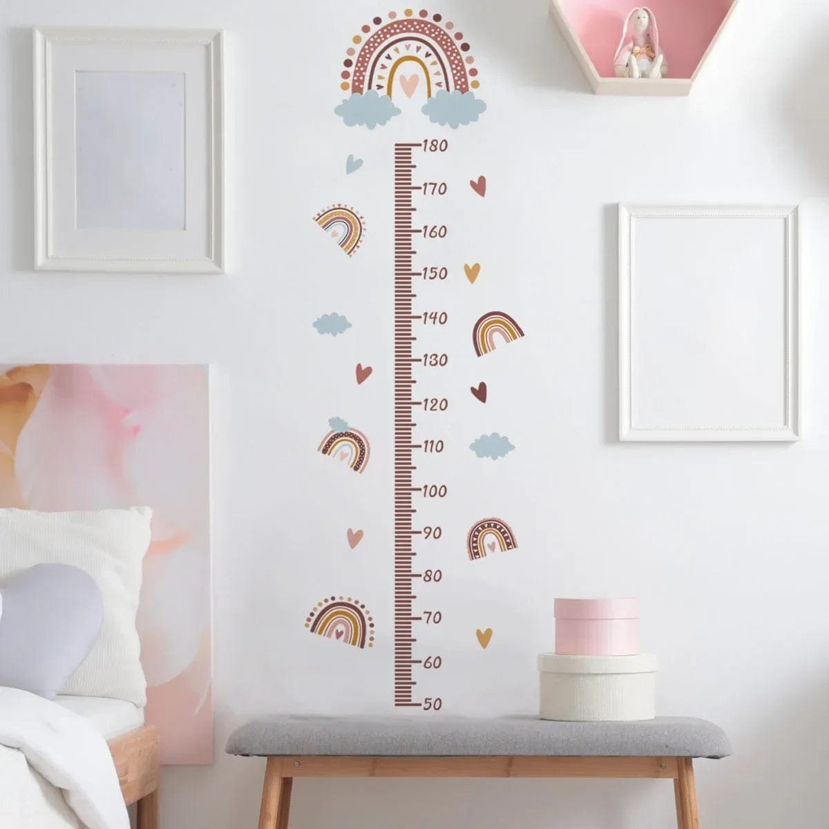Decorative height chart with rainbow and cloud design on a wall in a room.