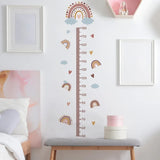 Decorative height chart with rainbow and cloud design on a wall in a room.