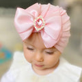 Pink rhinestone bowknot baby turban worn by a toddler for photoshoots, parties, and everyday cute styling.