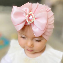 Pink rhinestone bowknot baby turban worn by a toddler for photoshoots, parties, and everyday cute styling.