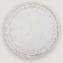 Round white cloth with pink polka dots and frayed edge