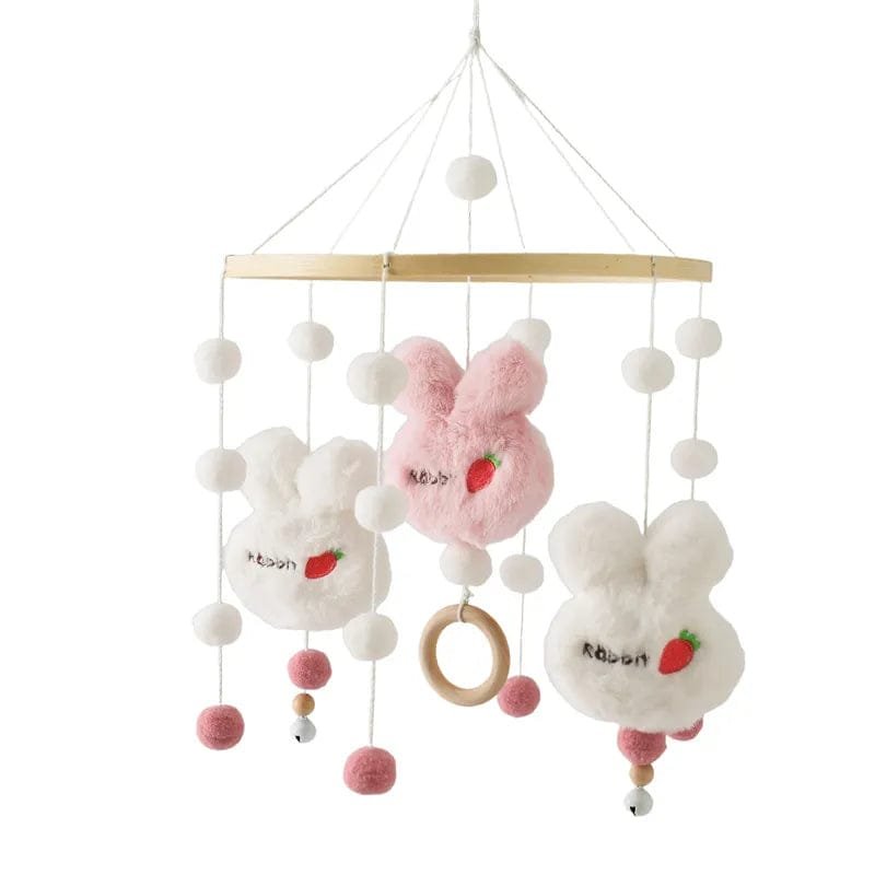 Plush bunny crib mobile with white ball pendants, a soft nursery toy that gently entertains babies in the cot.