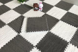 Checkered pattern of gray and white interlocking foam mats with small toys on top.