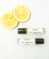 Two oil roller bottles labeled 'Boost' and 'Calm' with lemon slices.