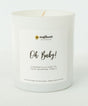White candle with 'Oh Baby!' text and 'sunflower motherhood' branding.