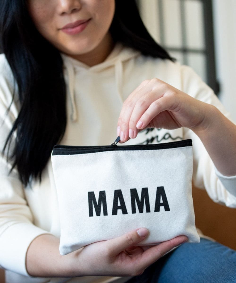 Person holding a white pouch with 'MAMA' printed on it