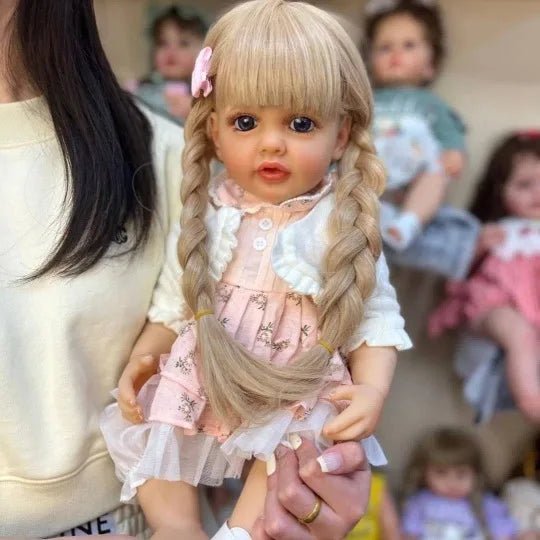 Premium full silicone Reborn Doll Betty Princess in a pink dress held in hand, showing weight and size for collectors.