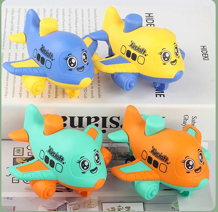 Four cartoon aircraft toys in blue, yellow, mint green and orange sitting on top of a book