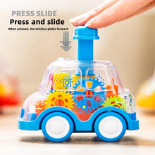 Hand pressing the button on top of a transparent blue gear toy car to make it glide forward