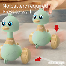 Two green press-and-swing duck toys with a hand pressing one and a no battery required note