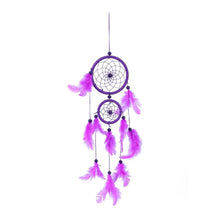 Purple feather rattan dream catcher photographed on a white background as wall art.