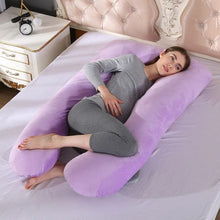 Purple U shaped pregnancy body pillow cushioning the belly and back for easier sleep in later trimesters.