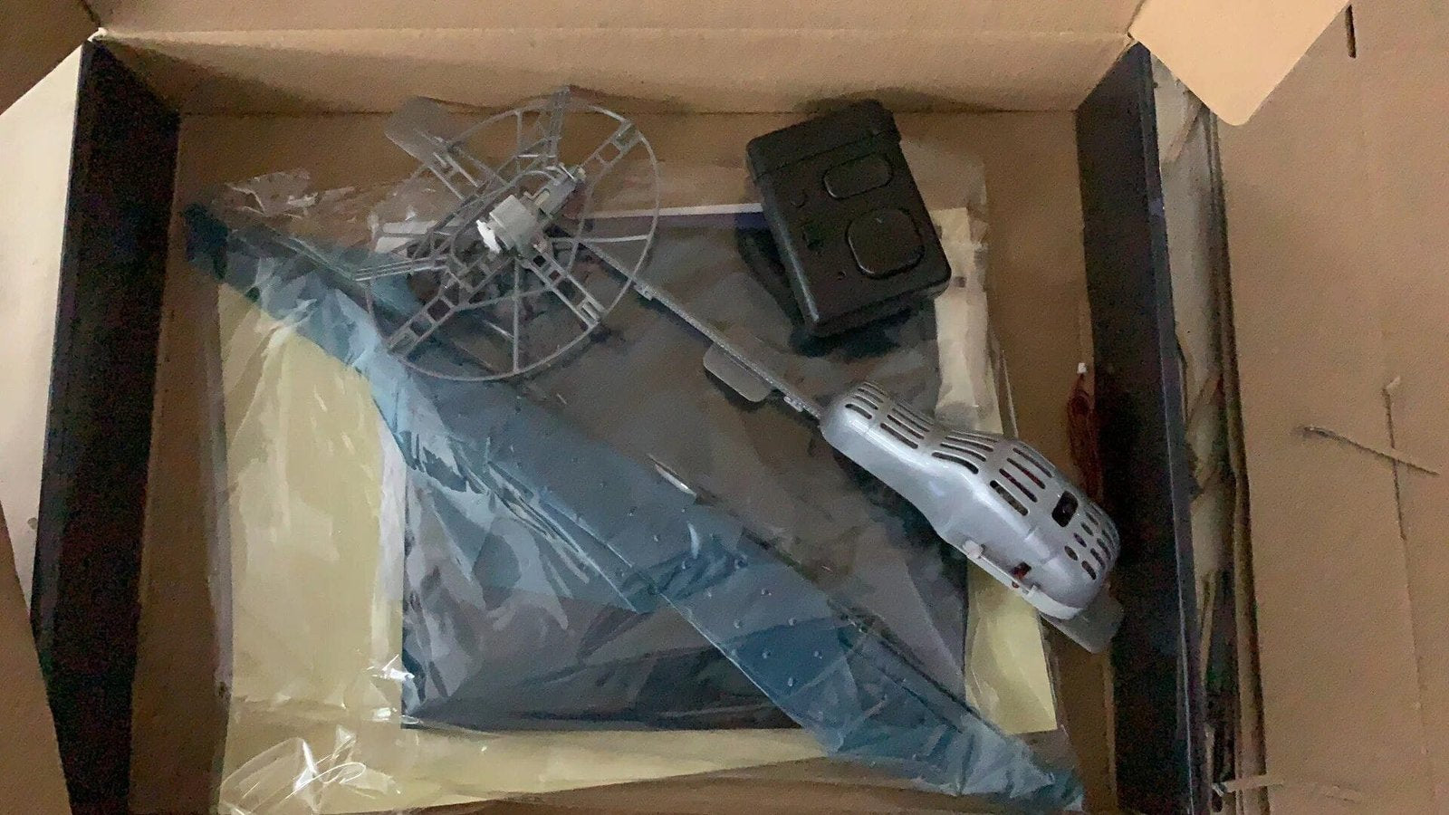 RC Flying Shark Balloon accessories and setup kit inside packaging for assembling the remote control flying toy.
