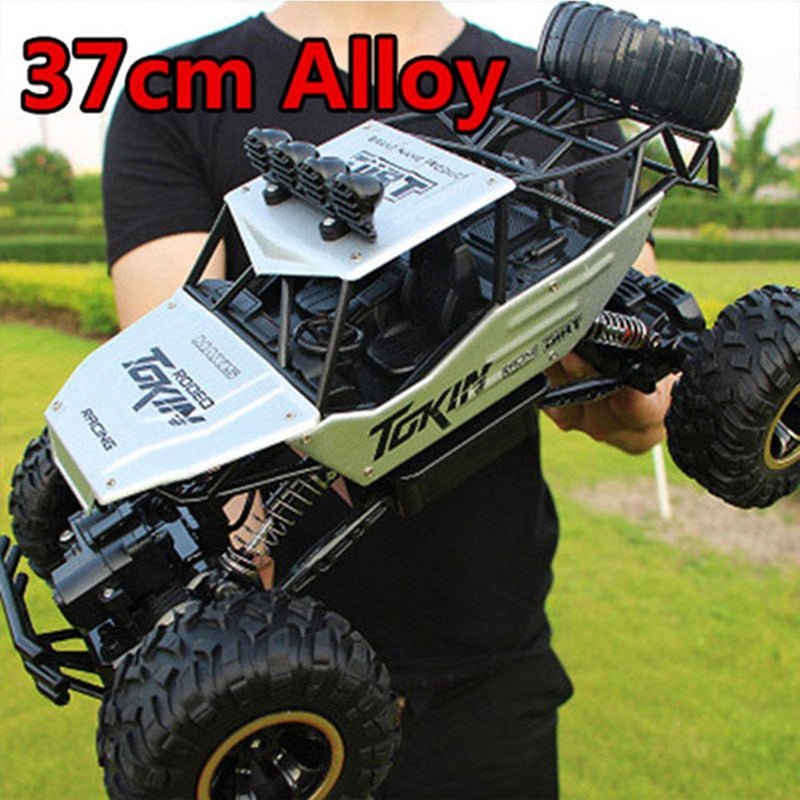 1:12 scale RC off-road truck used outdoors with the 2.4G radio controller in hand.