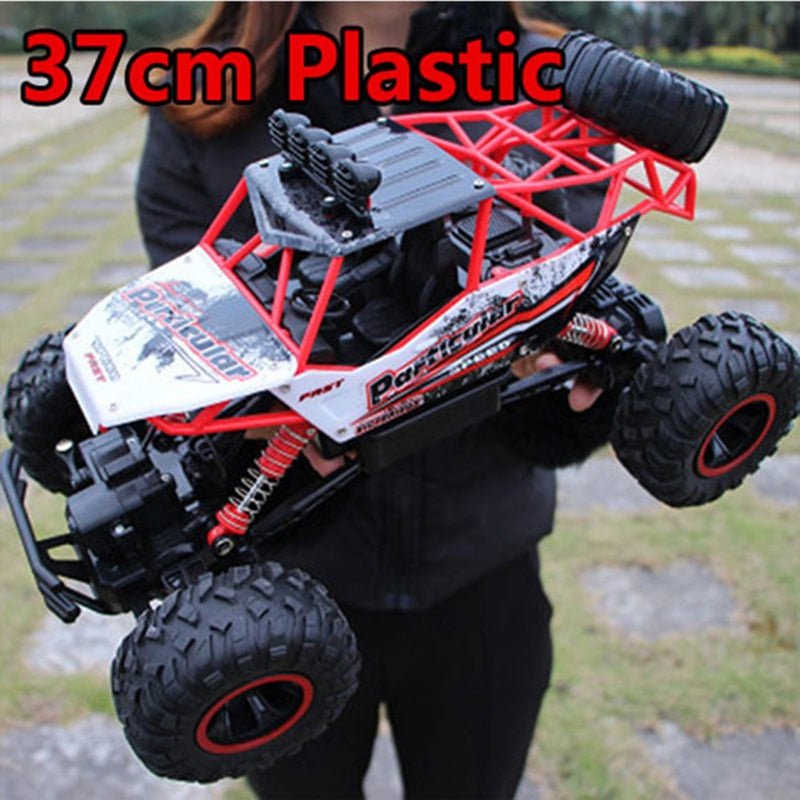 Plastic body 1:12 scale RC truck held outdoors ready for off-road remote control driving.