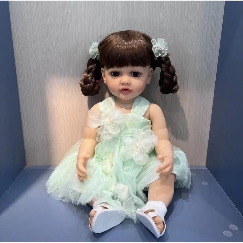 Real touch full silicone Reborn Doll Betty Princess in a green dress sitting upright for display, cuddling, and photo props.