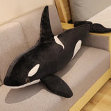 Plush toy shaped like a whale on a couch