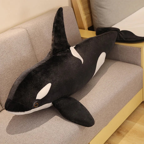 Plush toy shaped like a whale on a couch