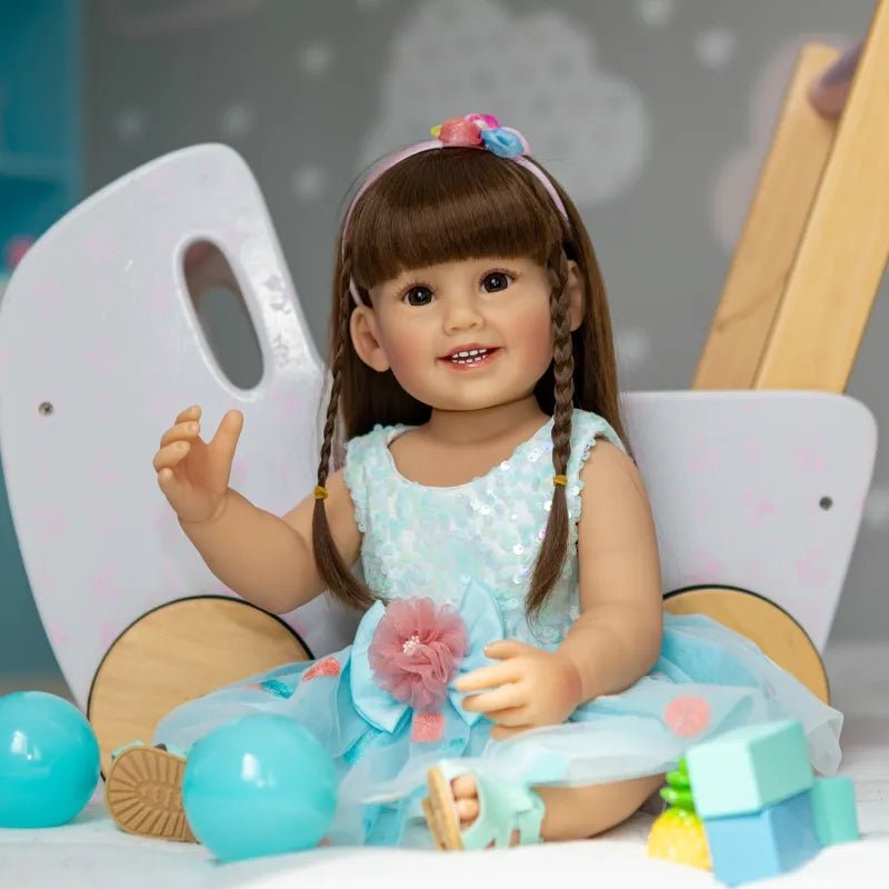 Realistic Reborn Toddler Doll in a blue skirt with toy accessories for imaginative play, nursery display, and birthday gifting.